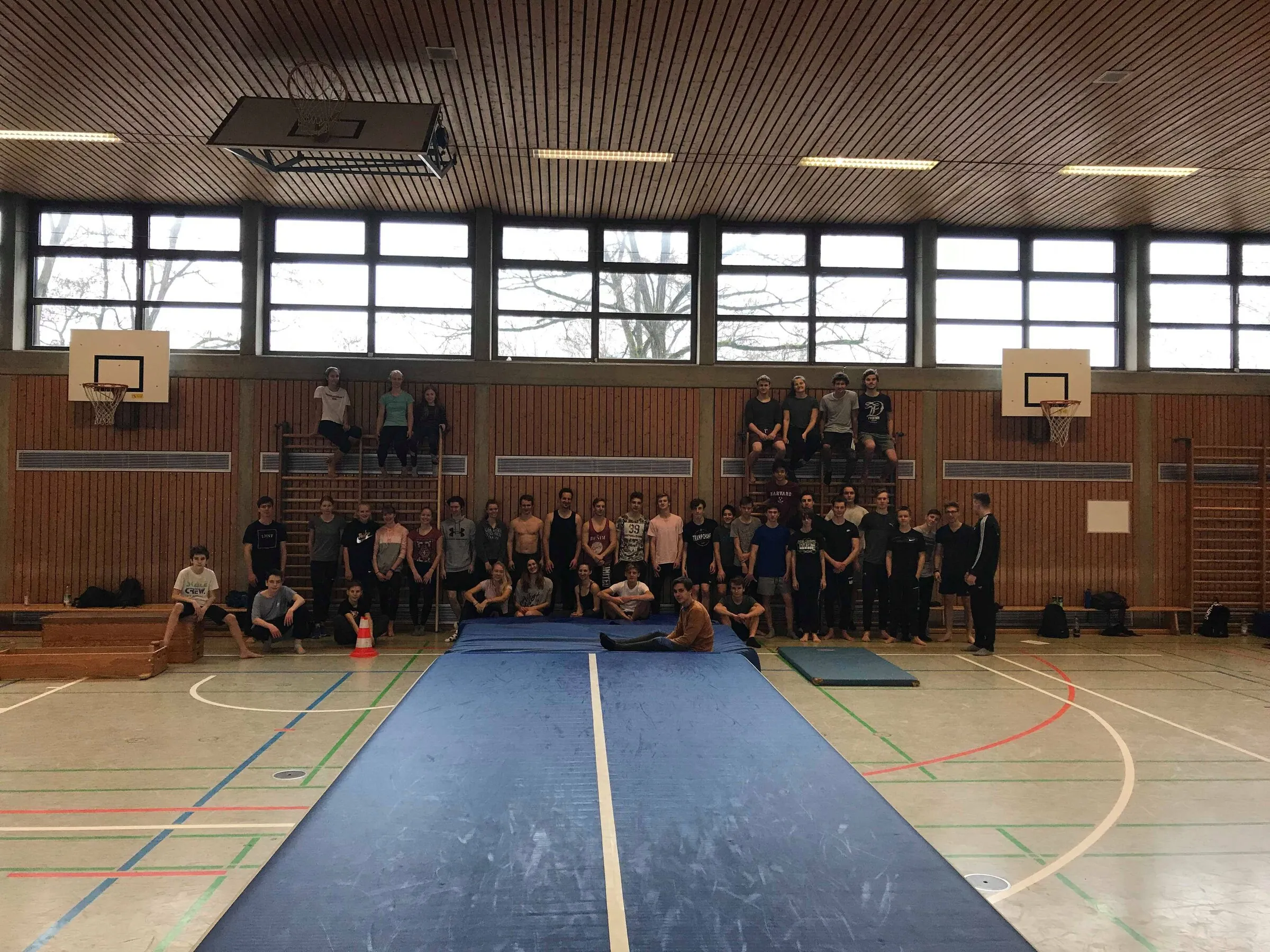 Die Rosenheimer Trainingsgruppe in der Sporthalle, davor eine ausgerollte blaue Turnmatte.