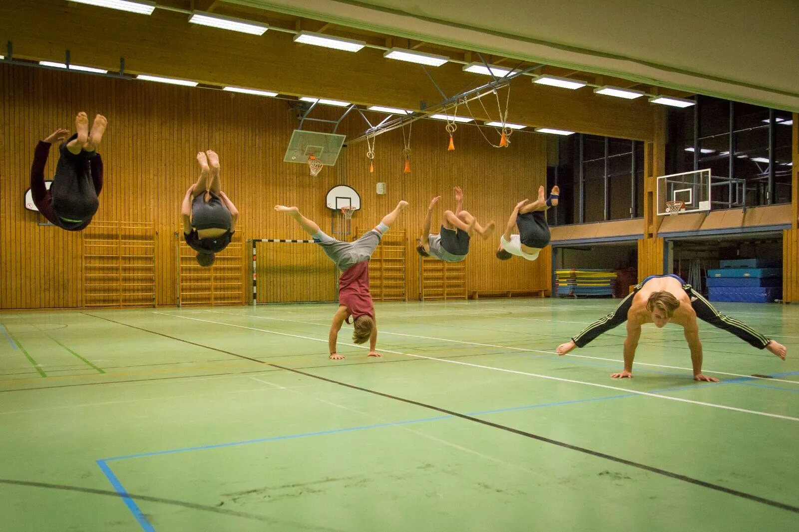 Ein Salto rückwärts in fünf Phasen quer durch die Sporthalle, daneben ein Handstand und eine Brücke.